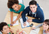 Group of young students studying together at library