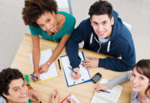 Group of young students studying together at library