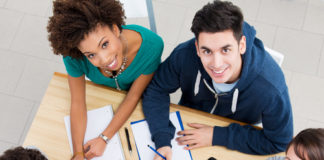 Group of young students studying together at library