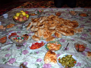 Kyrgyz village home, food spread on floor. 