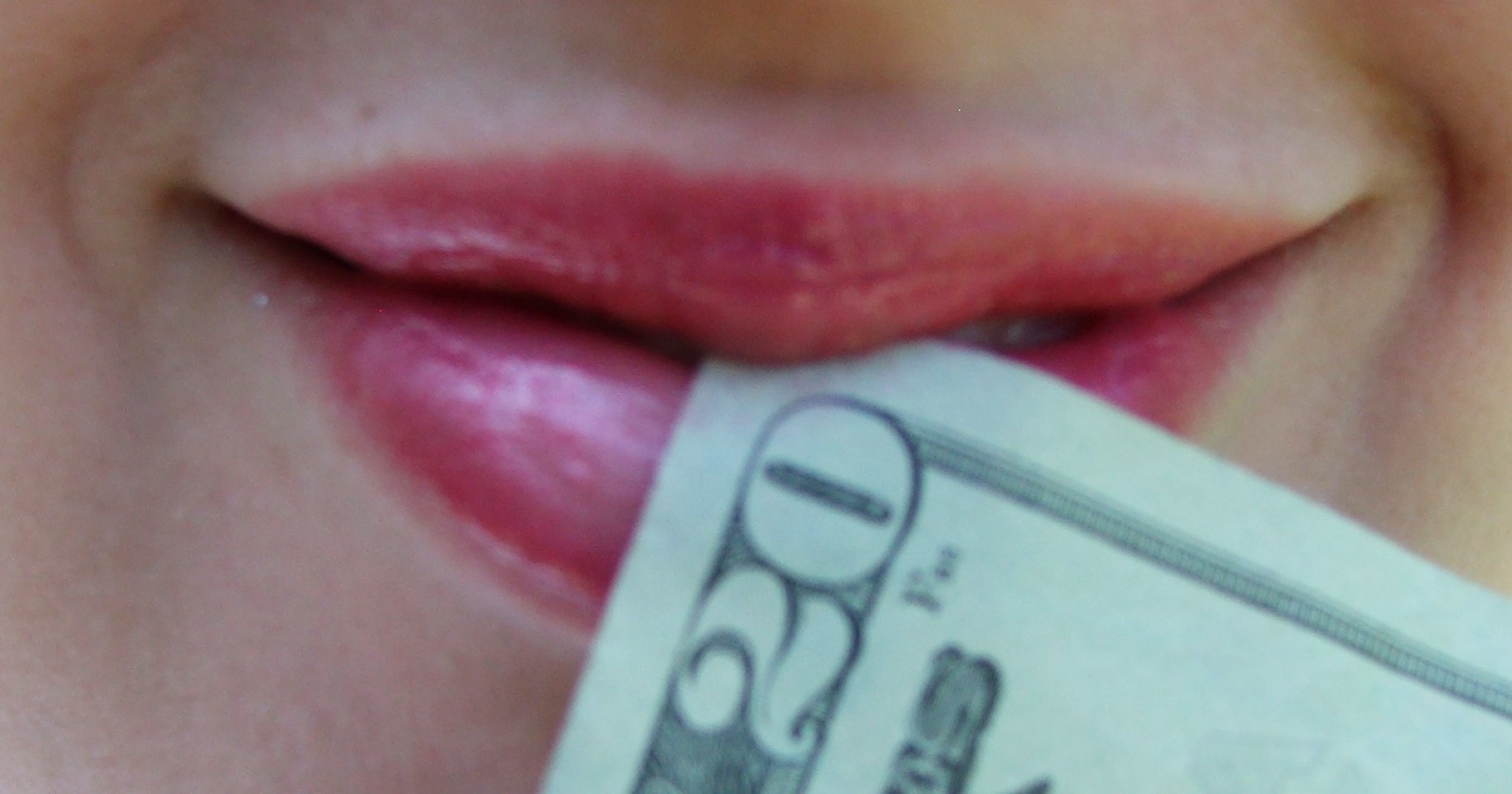 woman's mouth with $20 bill