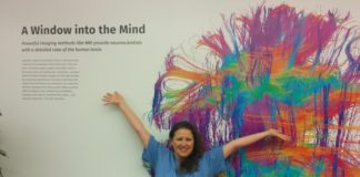 Susanna Zaraysky in scrubs in front of painting of the brain