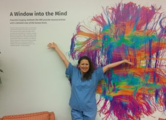 Susanna Zaraysky in scrubs in front of painting of the brain