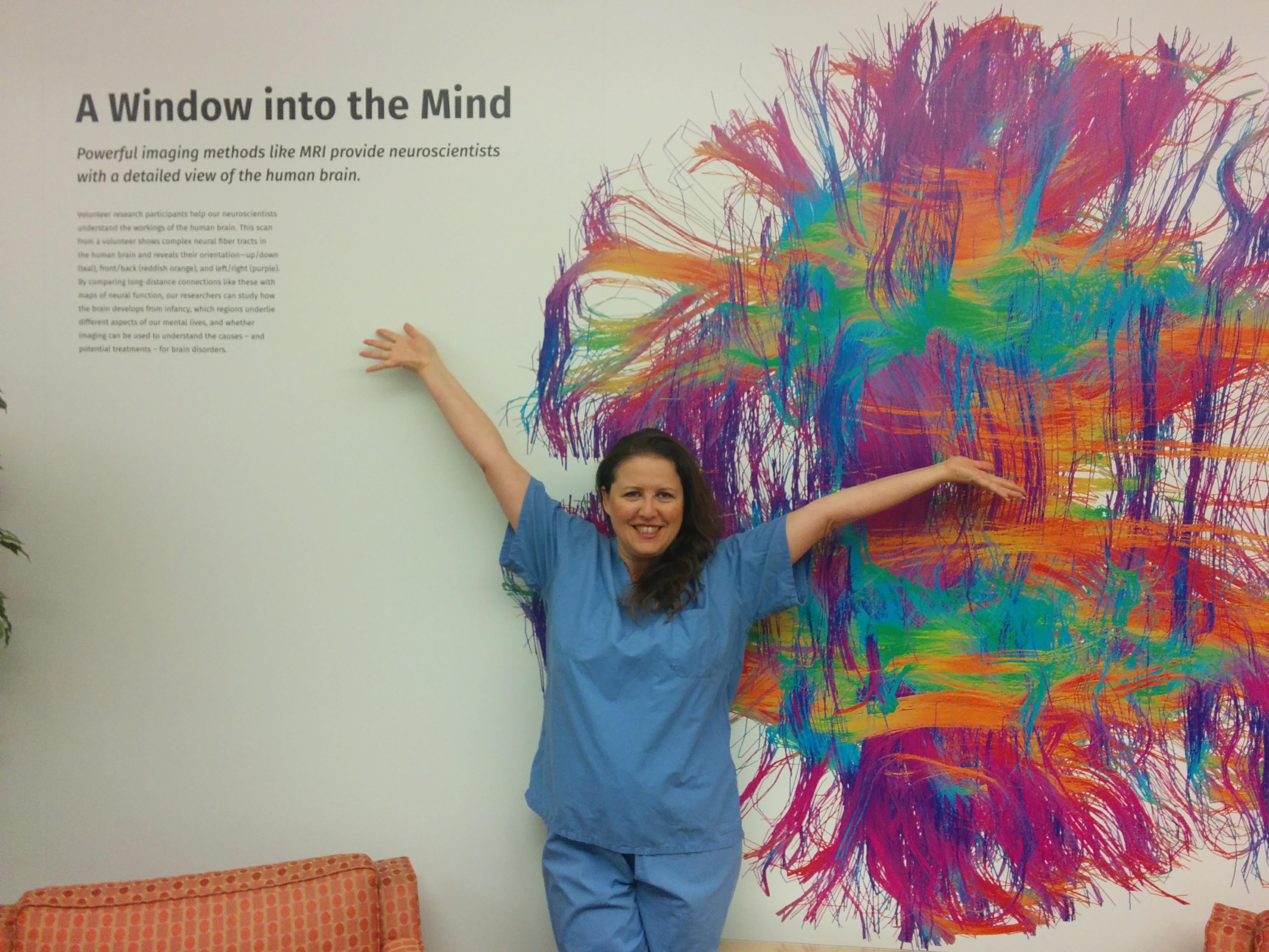 Susanna Zaraysky in scrubs in front of painting of the brain